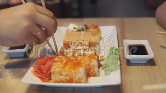 朋友在日本餐厅吃寿司卷寿司吧晚餐视频的预览图