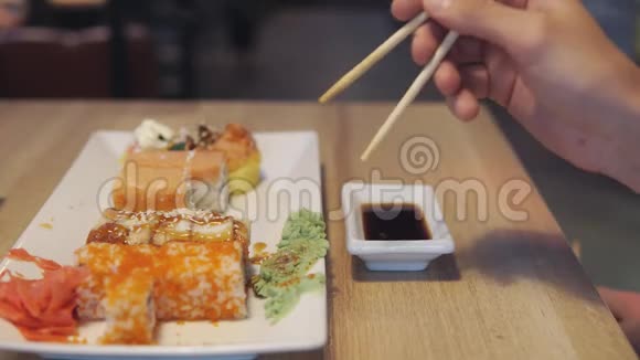 朋友吃寿司在寿司吧里蘸酱视频的预览图