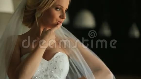 美丽活泼的金发新娘穿着白色礼服在餐厅背景摆姿势视频的预览图