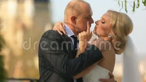美丽的新婚夫妇在教堂背景下轻轻地接吻视频的预览图