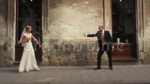 新婚夫妇在老利沃夫市的大街上玩得开心视频的预览图