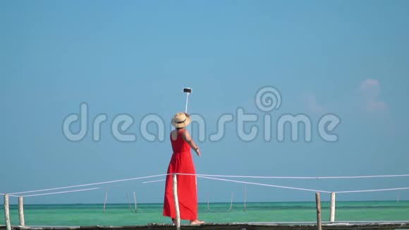 一位漂亮的女士在自拍棒上用动作摄像机拍摄自己的视频视频的预览图