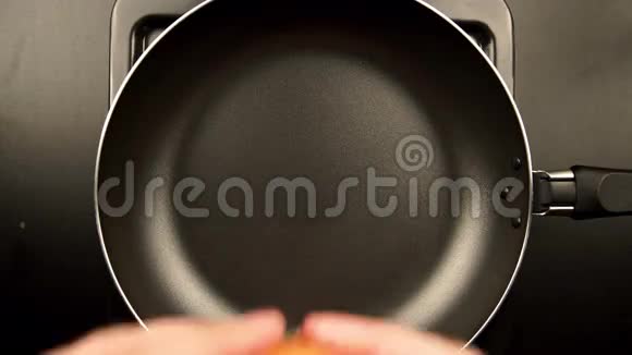 顶部视图人的手把鸡蛋放在煎锅上视频的预览图