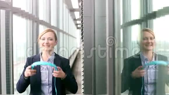 微笑的女商人用耳机听音乐跳舞视频的预览图