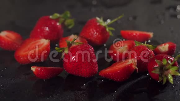 草莓在水中溅在黑色背景上视频的预览图