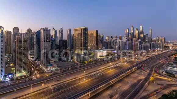 迪拜码头与交通在谢赫扎耶德公路全景白天到晚上延时灯打开视频的预览图