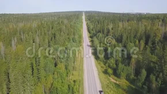 俯视风景蜿蜒的乡村道路穿过绿色农田剪辑空中乡村公路蓝天视频的预览图
