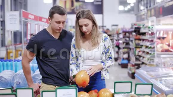 年轻夫妇在超市里摘水果视频的预览图