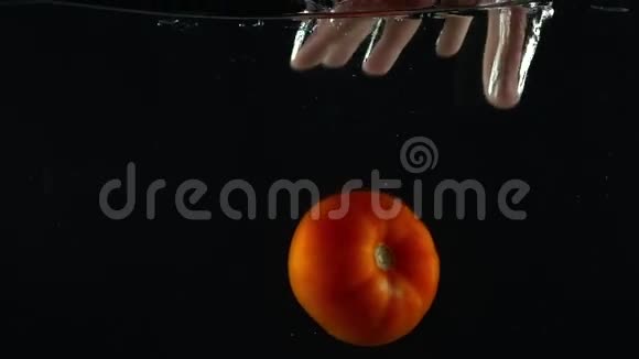 男子手伸出手抓住漂浮在水面下的番茄超慢动作镜头视频的预览图