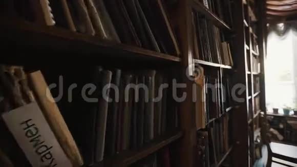 多莉在旧风格的图书馆内部拍摄书架俄文版花盆视频的预览图