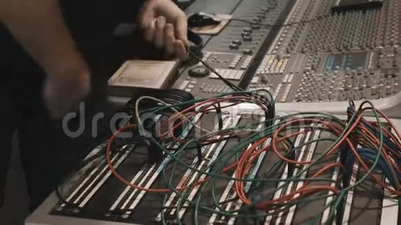 在音乐混音控制台上用手拉很多电线视频的预览图