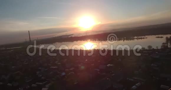 空中观景湖面上日落岸边有一座小城市工业工厂在地平线上4K视频的预览图