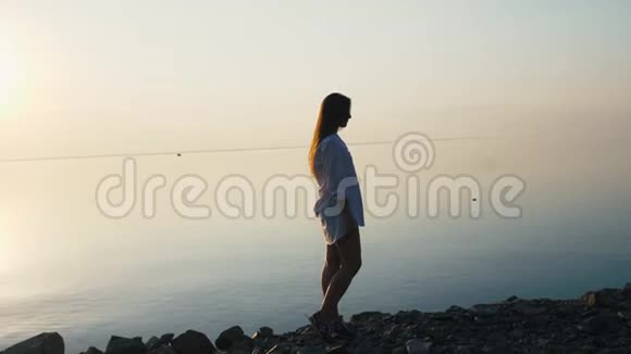 日落时分在海滩上慢动作奔跑的女人视频的预览图