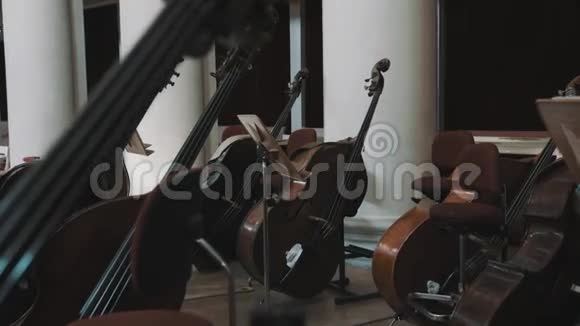 在古典音乐风格的音乐厅里几个大提琴手在现场的多利镜头视频的预览图