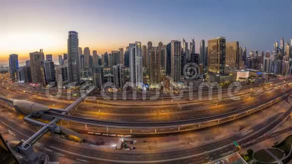 迪拜码头与交通在谢赫扎耶德公路全景白天到晚上延时灯打开视频的预览图