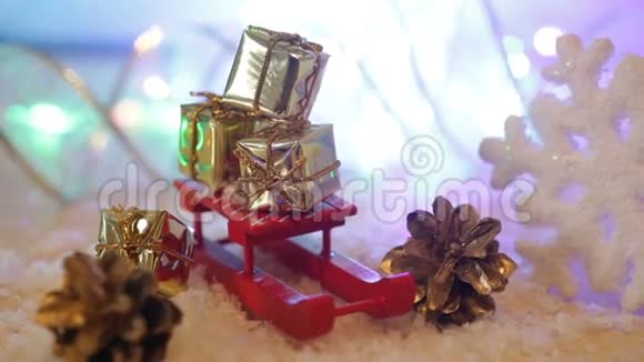 带礼物的盒子放在红色玩具雪橇圣诞背景上视频的预览图