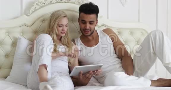 双人卧床使用平板电脑混种男女笑早卧室视频的预览图