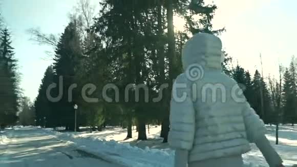 阳光明媚的一天年轻的运动女子在雪地公园散步视频的预览图