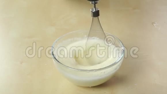 用手提搅拌器在玻璃碗中配制奶油视频的预览图