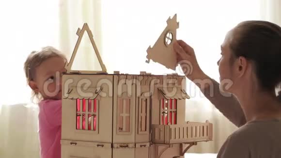 年轻女子为她的小女儿建造玩偶屋视频的预览图