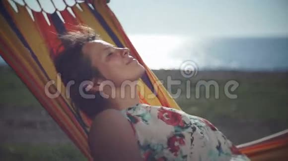 可爱的女孩在海上的吊床上享受休闲视频的预览图
