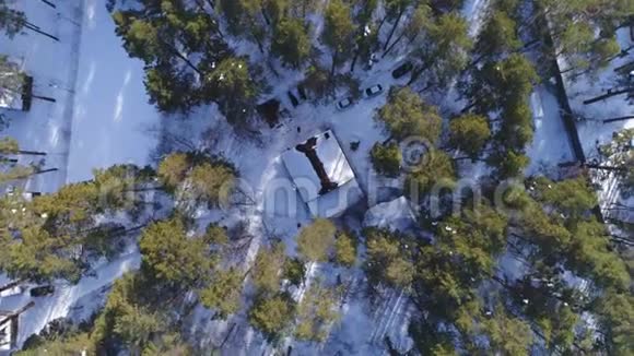 林中白雪覆盖的房子的鸟瞰图视频的预览图