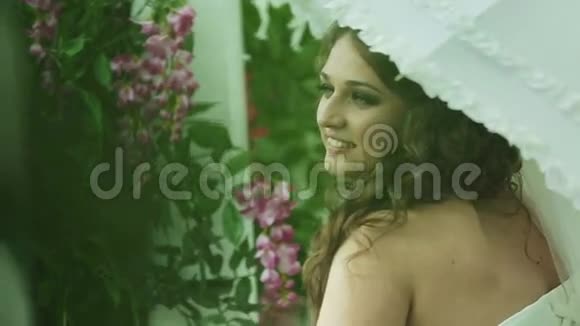 年轻的新娘带着白色的雨伞视频的预览图