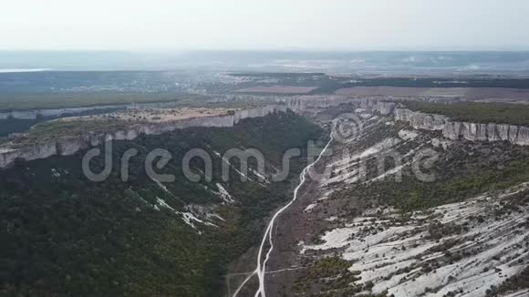 鸟瞰峡谷中间的一个跨度悬崖的一侧森林的另一侧在中间视频的预览图