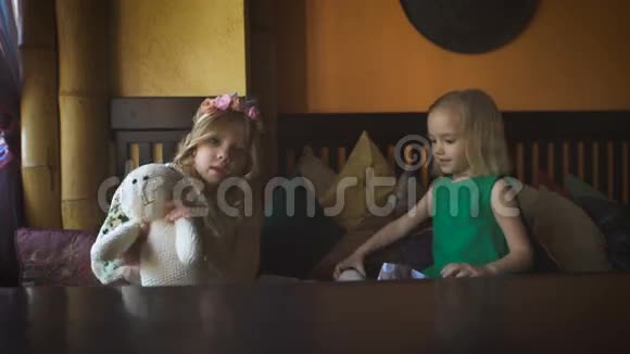 两个可爱的小女孩在咖啡馆里玩耍视频的预览图