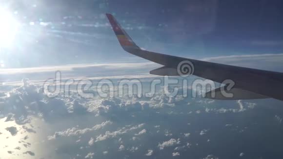 在阳光明媚的一天乘用飞机飞越稀少的云层和海面上空视频的预览图