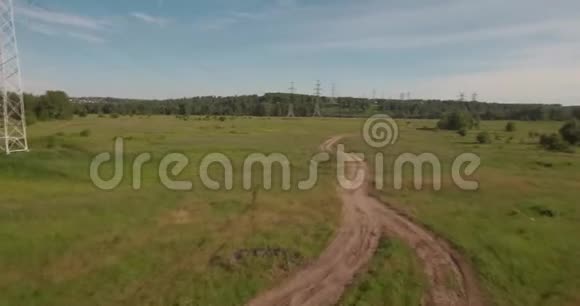 空中观景农村公路之间的农田和电力高压支架绿色田野之间的乡村道路4K视频的预览图
