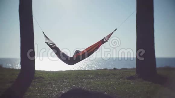 可爱的女孩在海上的吊床上享受休闲视频的预览图