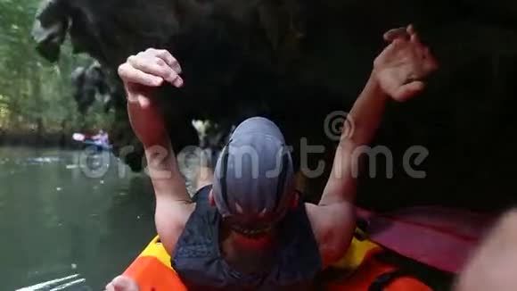 老人在皮艇上漂流穿过悬空的洞穴视频的预览图