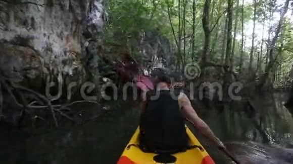 老人在丛林之间的暗河口划皮艇视频的预览图