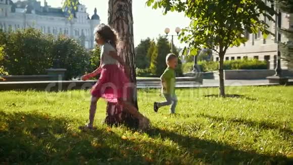 日落时在夏季公园玩耍的孩子们小男孩和小女孩慢动作视频的预览图