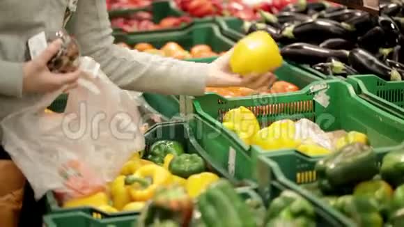 一个超市里的女人在蔬菜货架上挑选蔬菜视频的预览图