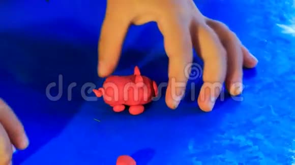 小孩的手在玩塑料蓝色玩具猪视频的预览图