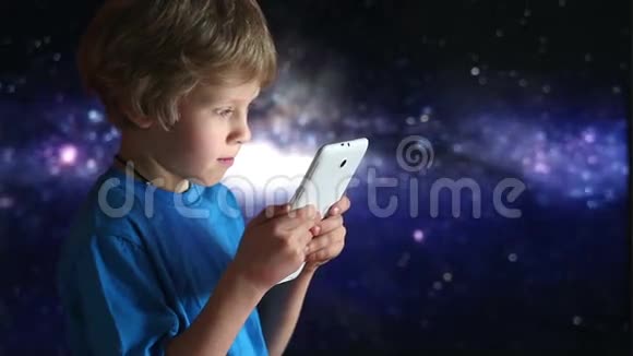 玩平板电脑的男孩坐在宇宙天空背景上的手中的男孩和平板设备视频的预览图