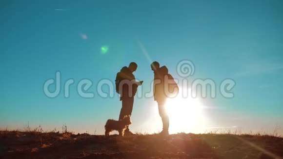 团队合作两名游客徒步旅行男人和狗带着背包在日落时去徒步旅行慢动作视频智能手机视频的预览图