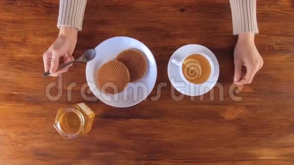 女人喝着柠檬蜂蜜和华夫饼的茶视频的预览图