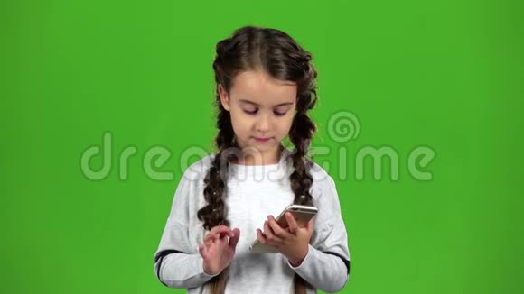 孩子在打电话绿色屏幕慢动作视频的预览图