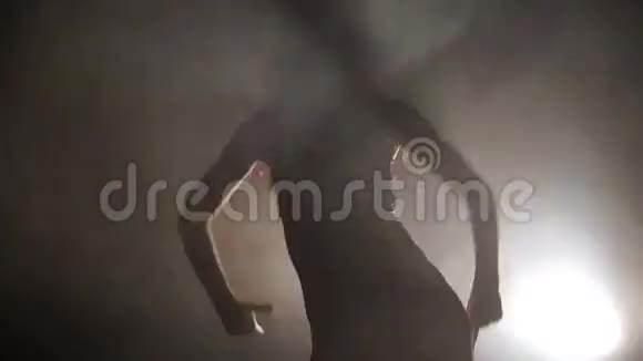 一个女孩在灯光的背景下热情地跳舞的剪影视频的预览图
