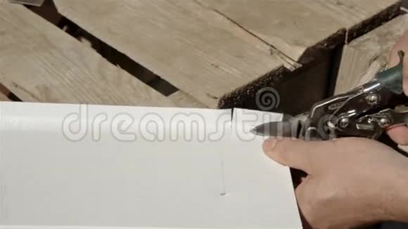 一个建筑工地的工人切割金属切割的不锈钢薄板剪刀视频的预览图