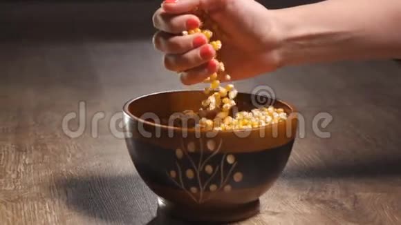 女人的手把爆米花倒进碗里视频的预览图