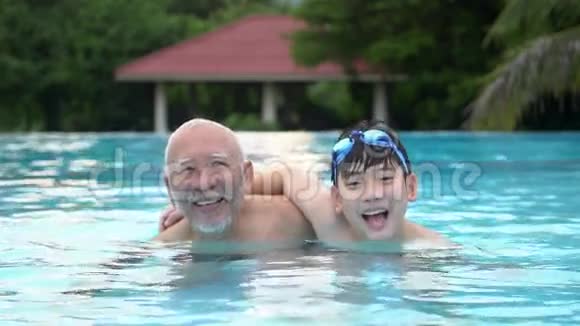 欢乐亚洲家庭在游泳池中玩耍的慢动作视频的预览图