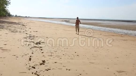 老人在低潮时沿着海滩慢跑视频的预览图