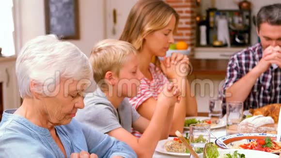 可爱的家人在吃晚饭前祈祷视频的预览图