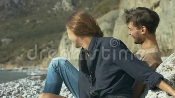 年轻夫妇坐在沙滩上拥抱视频的预览图
