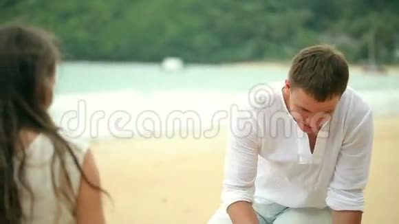 浪漫的年轻夫妇在沙滩上画心形视频的预览图