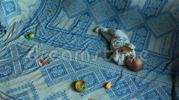 婴儿躺在床上玩玩具时视频的预览图